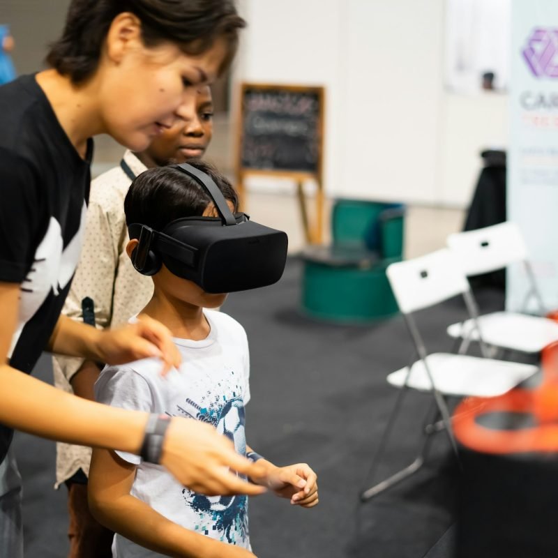 young-boy-using-virtual-reality-gear-with-adult-at-the-digital-fair.jpg